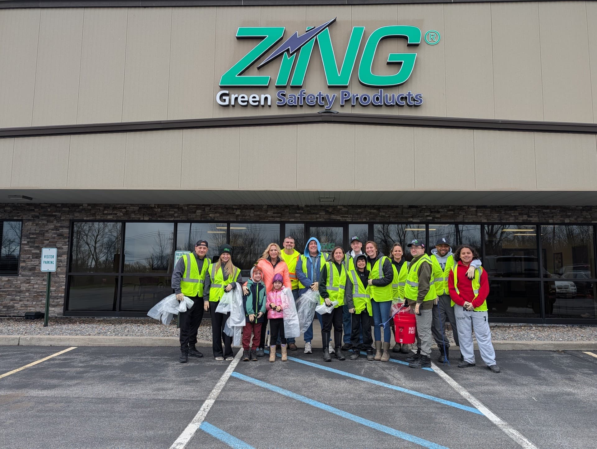 Zing Green Products employees and family members wearing high-visibility vests for a community cleanup event